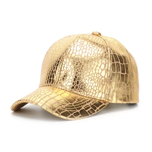 Vue détaillée du tissu à texture peau de crocodile dorée sur la casquette de baseball
