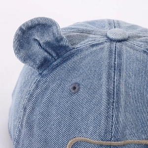 Vue macro d'un chapeau en denim pour bébé avec oreilles d'ours et broderie détaillée