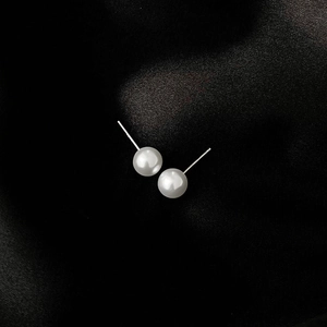Classic round white pearl stud earrings on black silk background with S925 silver needles