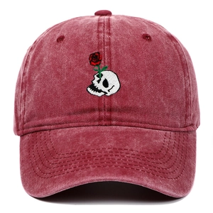 Close-up of vintage wine red baseball cap with skull and rose embroidery detail