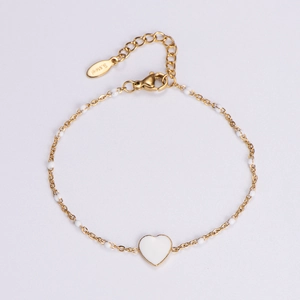 Detail of 18k gold plated stainless steel heart bracelet with white beads and lobster clasp