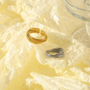 Macro detail of French twisted wheat pattern rings in gold and silver stainless steel