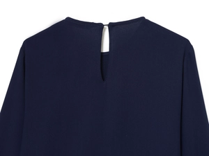 Détail d'une robe courte bleu marine avec décolleté goutte au dos et fermeture boutonnée