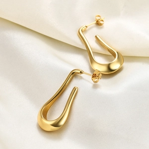 Detailed macro view of gold-plated 304 stainless steel teardrop earrings on silk