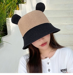 Close-up of woven bucket hat with cute black bear ears and khaki contrast design