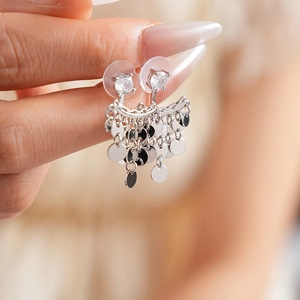 Detail shot of silver fringe earrings with cubic zirconia studs worn by a model