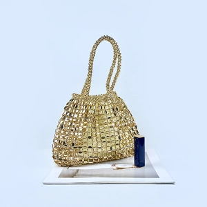 Close-up of golden woven metal handbag with sequins and hollow mesh structure