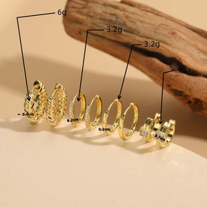 Set di quattro orecchini a cerchio dorati con zirconi e design a treccia e pesi