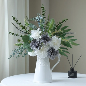 Artificial dahlia bouquet with eucalyptus in white ceramic vase for home table decor