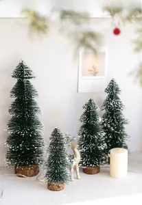 Mini green flocked Christmas trees with wooden bases and a golden reindeer statue