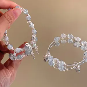 Detailed close-up of beaded bracelets with butterfly charms and silver bell pendants
