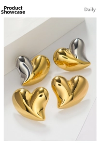 Close-up of 18K gold and silver heart earrings with a polished mirror finish surface
