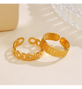 Detail of two 18K gold plated stainless steel open rings with chain and carved patterns