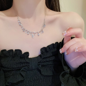 Detailed view of silver branch-shaped necklace with dangling water drop crystals on a model
