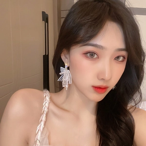 Boucles d'oreilles nœud vintage avec perles et zircons portées pour un look élégant