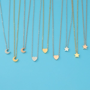 Detail of star, heart, and moon pendants on fine chains in gold, silver, and rose gold finishes