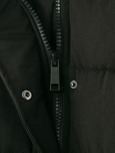 Détail macro d'une fermeture éclair en métal noir et de boutons-pression sur une veste
