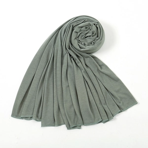 Detail of soft sage green knit fabric texture with high-quality stitching on the edges