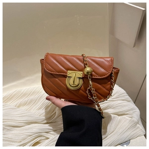 Detail of caramel brown quilted PU leather bag with gold chain and spherical metal buckle