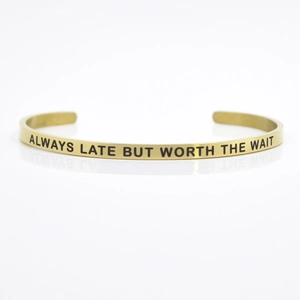 Macro shot of gold stainless steel cuff bracelet with ALWAYS LATE BUT WORTH THE WAIT engraving