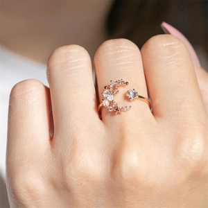 Close-up of a rose gold moon and star open ring with sparkling cubic zirconia on a hand