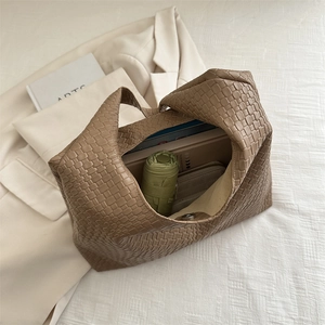 Large khaki woven shoulder bag for women with spacious interior shown from a top view