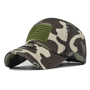 Close-up of camouflage baseball cap with embroidered American flag patch and frayed brim