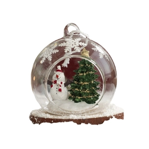 Clear glass Christmas ornament with snowman and tree on wooden base for festive decor