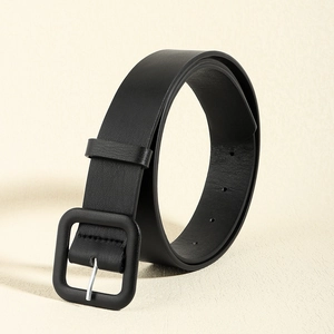 Detailed macro view of matte black square buckle and leather texture on a woman belt