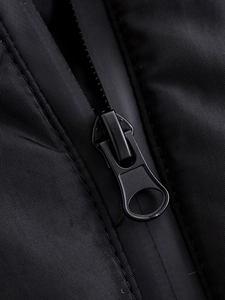 Close-up of waterproof black zipper with metallic puller on a functional hooded jacket