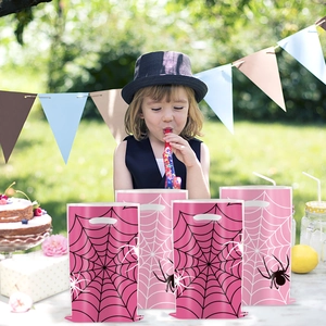Pink spider web gift bags in a garden birthday party setting with outdoor decorations