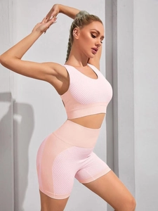 Detail of pink and orange seamless honeycomb textured fabric on sports bra and shorts