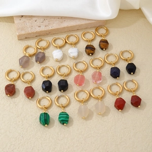 Detailed arrangement of colorful geometric natural stone pendants on gold hoops