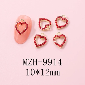 Detailed view of red heart nail charm with gold metal base and sparkling rhinestones