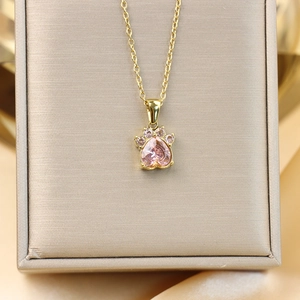 Gros plan du pendentif patte de chat avec zircon coeur rose et pierres scintillantes