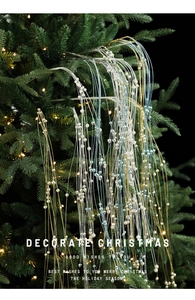 Détail de guirlandes de perles brillantes dorées, argentées et bleues sur le sapin