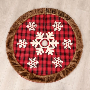 Red plaid Christmas tree skirt with white snowflake patterns and brown faux fur trim