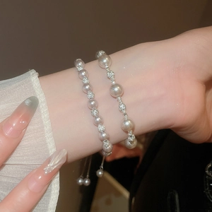 Détail d'un bracelet de perles multicouche avec strass et fermeture à cordon réglable