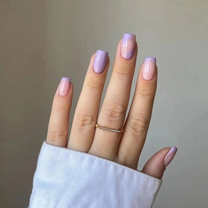 Gros plan sur ongles carrés avec lignes violettes ondulées et design French minimaliste