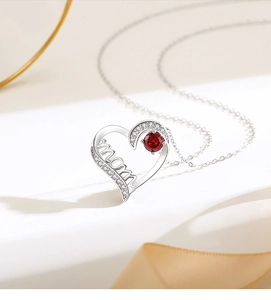 Close-up of S925 silver heart necklace with red gemstone and mom lettering pendant