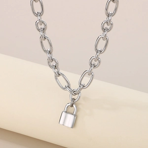 Detailed view of silver thick link chain with minimalist metal lock pendant on a pedestal