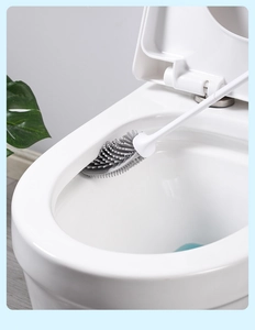 Close-up of flexible grey TPR toilet brush head cleaning under the rim of a toilet bowl