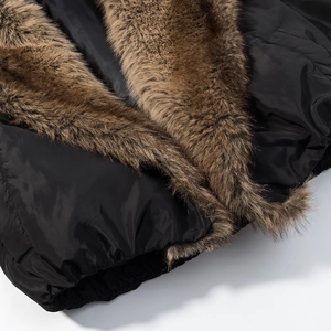 Detail of the brown faux fur collar and quilted black fabric on a winter jacket