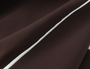 Macro shot of dark brown woven fabric with white contrast side stripe detail