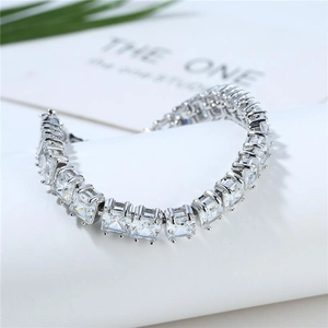 Macro detail of silver-toned tennis bracelet with square-cut cubic zirconia in prong setting