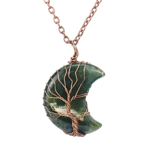 Macro detail of moss agate crescent moon pendant with handmade copper tree of life wire wrap