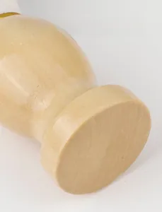 Detailed close-up of a wooden shaving brush handle with natural grain and gold ring
