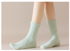 Close-up of soft light green coral fleece socks featuring warm plush cable knit texture