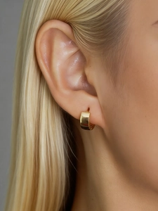Close-up of polished gold wide-hoop sterling silver earrings worn by a blonde model
