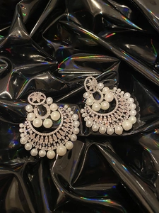 Macro view of gold plated pearl earrings with zircons in a vintage French crescent design